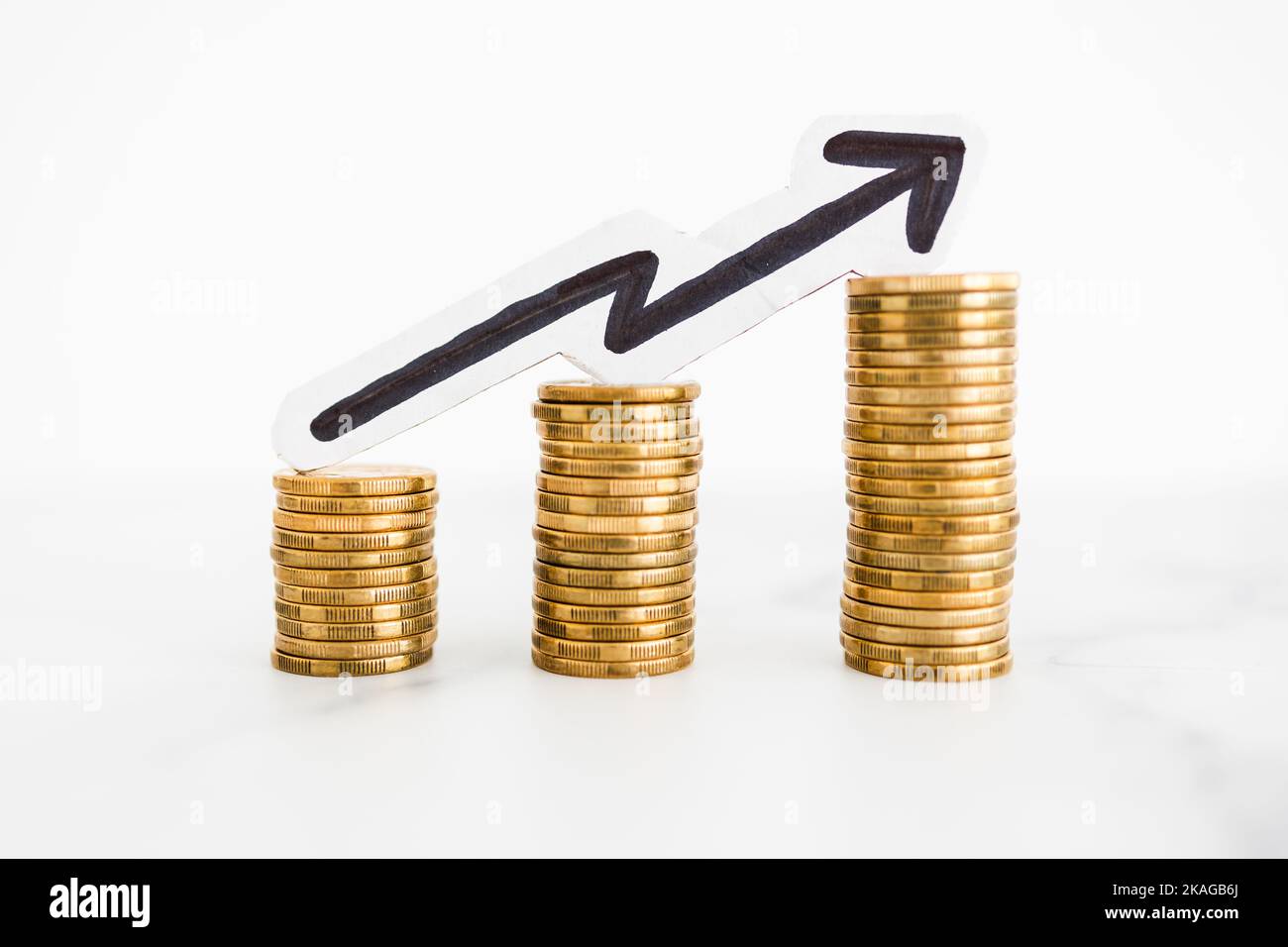growing stacks of coins with arrow pointing upward, metaphor of