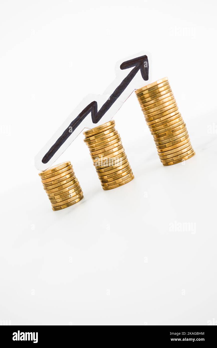 growing stacks of coins with arrow pointing upward, metaphor of
