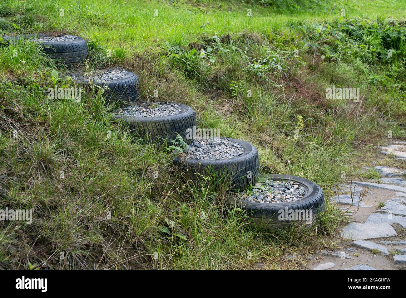 Old used car Tires filled with granite rock stones to make stairs on on