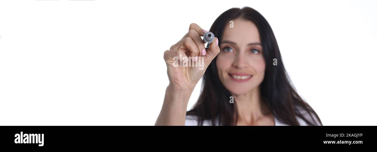 Smiling woman holding marker and writing something in air Stock Photo