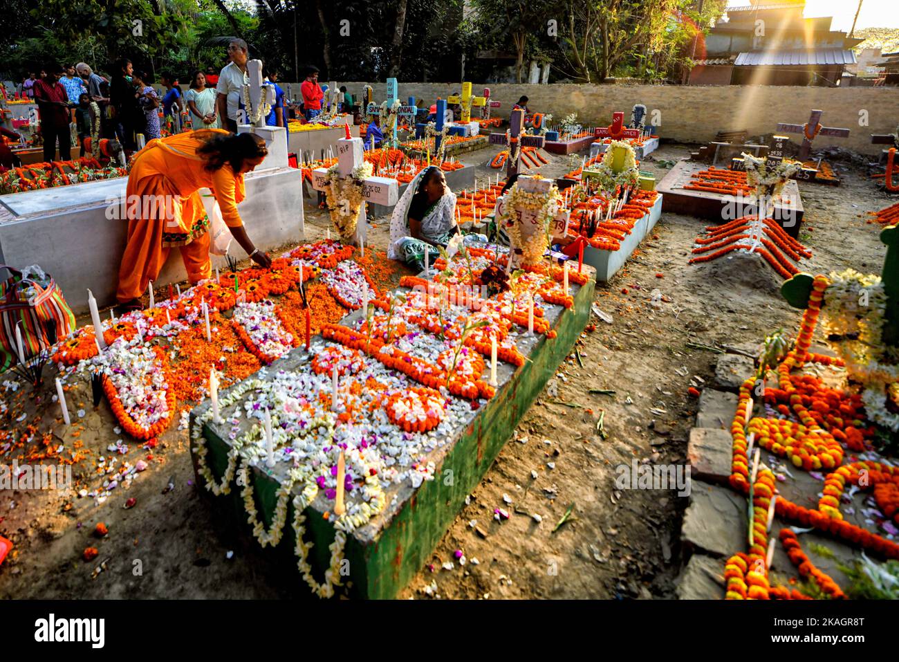 Christian family members pay respect and offer prayers beside the grave ...