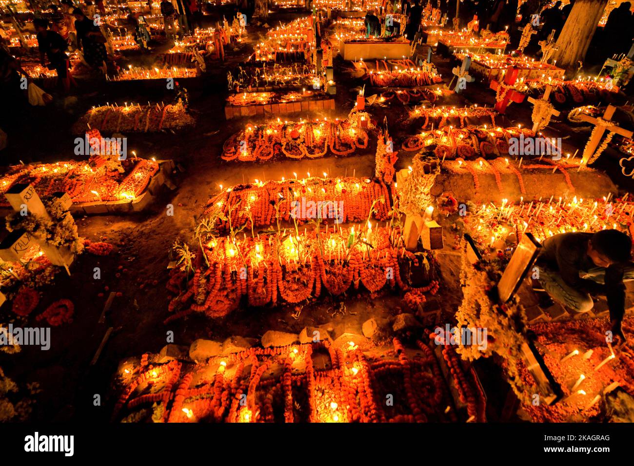 Christians light candles at the graves of their deceased relatives to