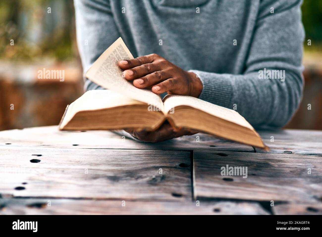Seeking for some answers. an unrecognizable man reading a book. Stock Photo