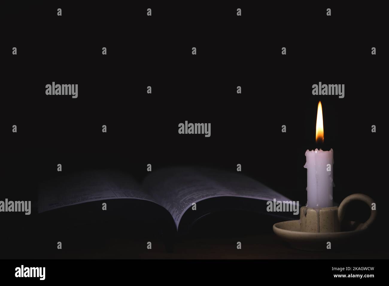 The brightly burning candle on the candlestick, the holy bible, and the