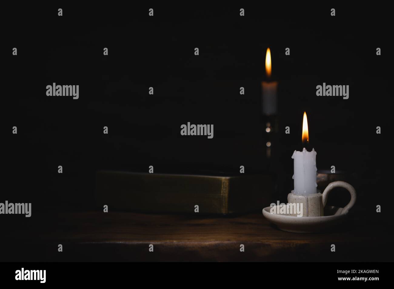 The brightly burning candle on the candlestick, the holy bible, and the