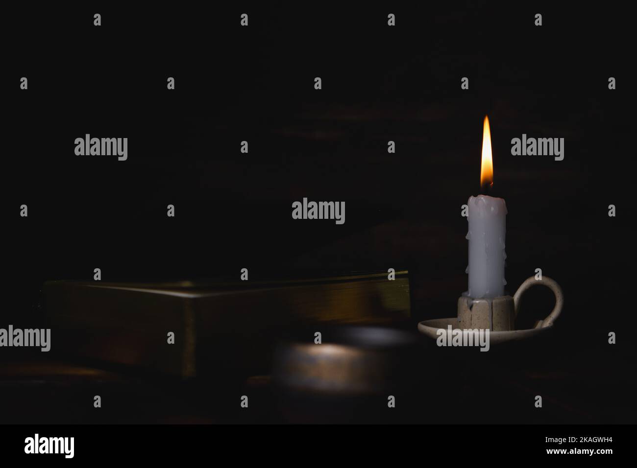 The brightly burning candle on the candlestick, the holy bible, and the