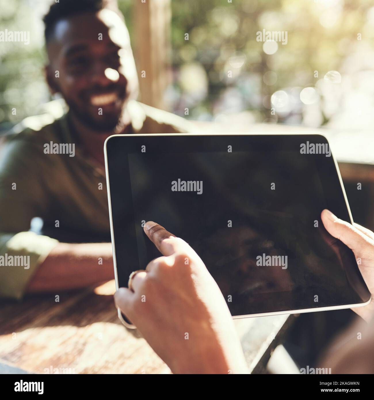 Placing an order just got smarter. a young man placing his order with a waiter using a digital tablet. Stock Photo