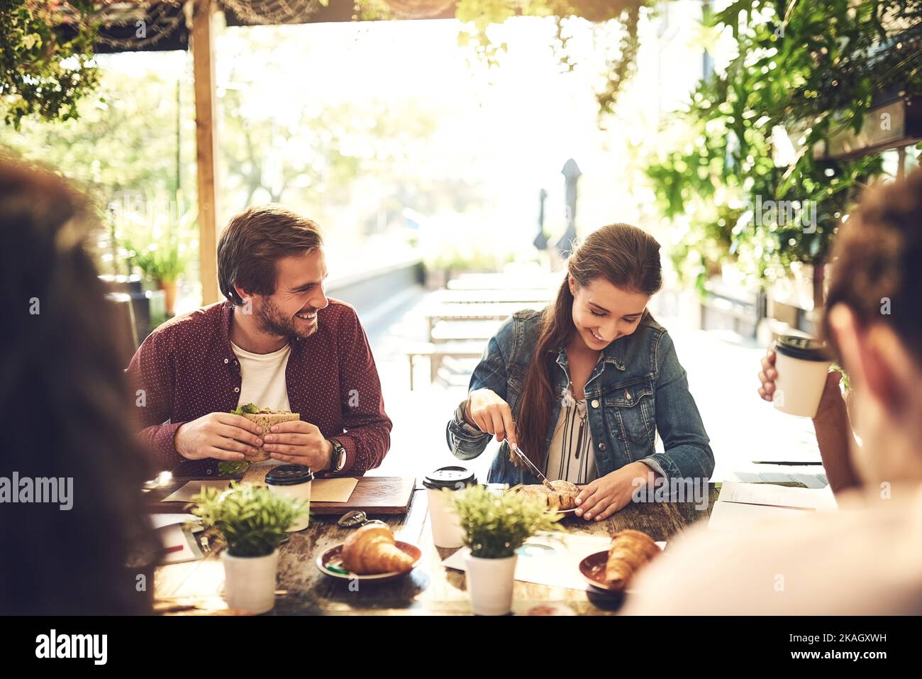 She cant wait to dig in. creative employees having a breakfast meeting outside. Stock Photo