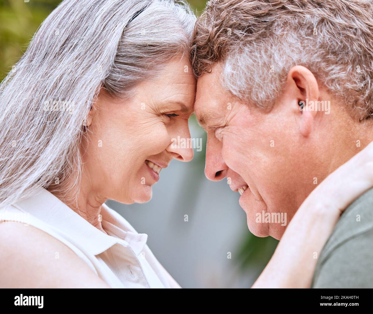 Love hug, forehead and senior couple bond, smile or happy on anniversary vacation for peace, trust or partnership. Romantic eye contact, marriage and Stock Photo
