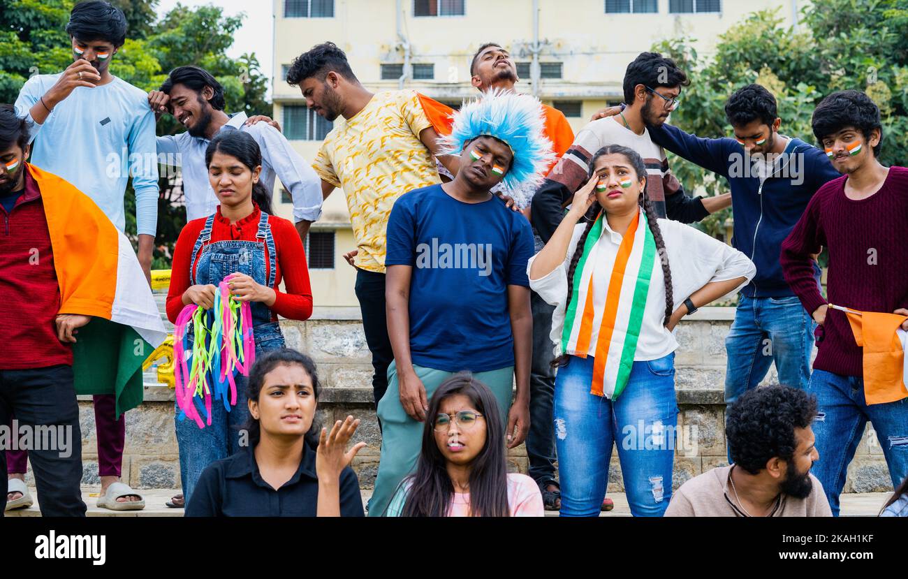 audience with Indian flags and wigs got sad due to loss of wicket while watching cricket sports match at stadium - concept of curious, disappointed Stock Photo