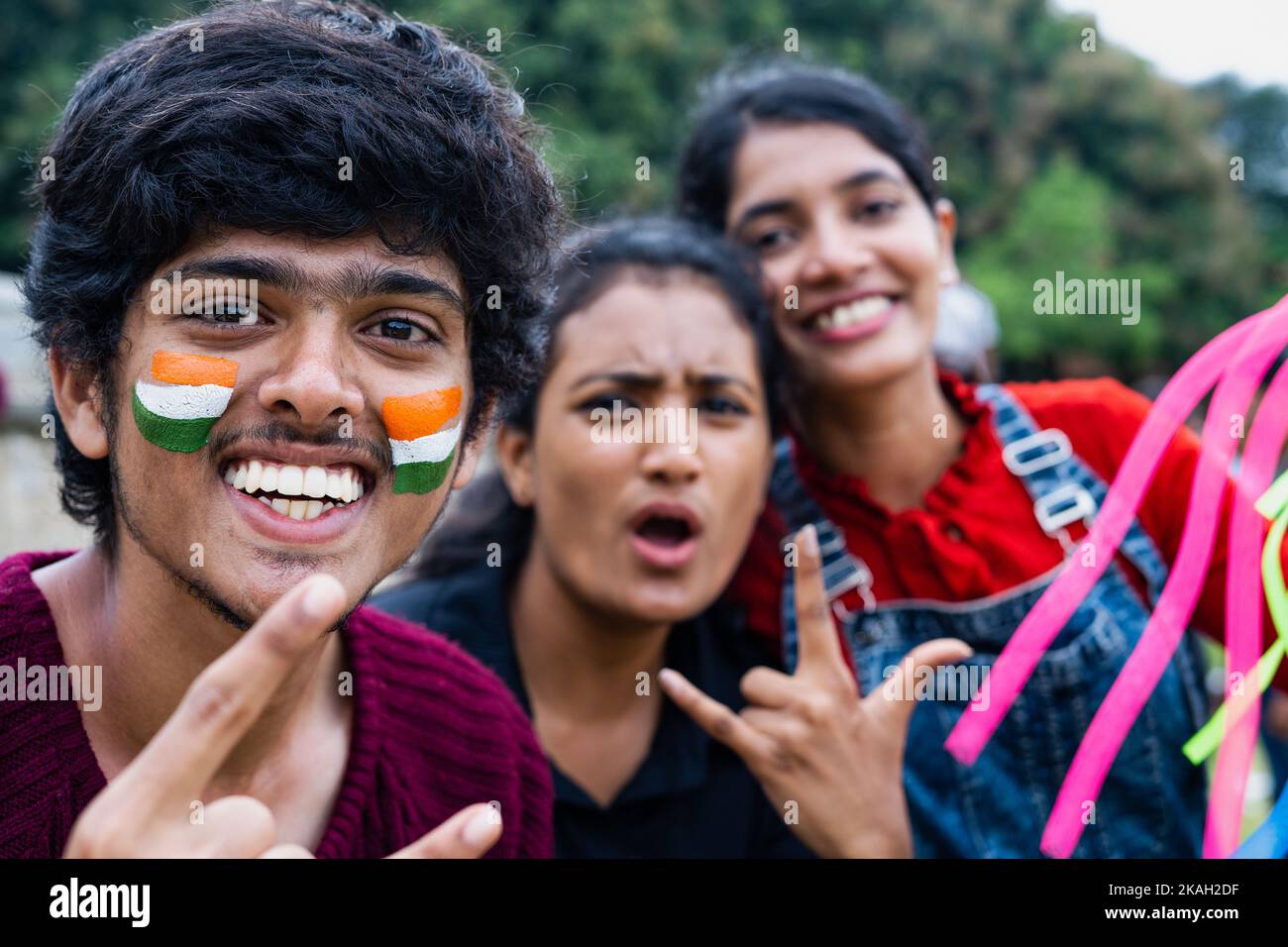 focus on boy, cheerful excited happy friends with painted indian flag on face shouting during watching sports at stadium after win - concept of Stock Photo