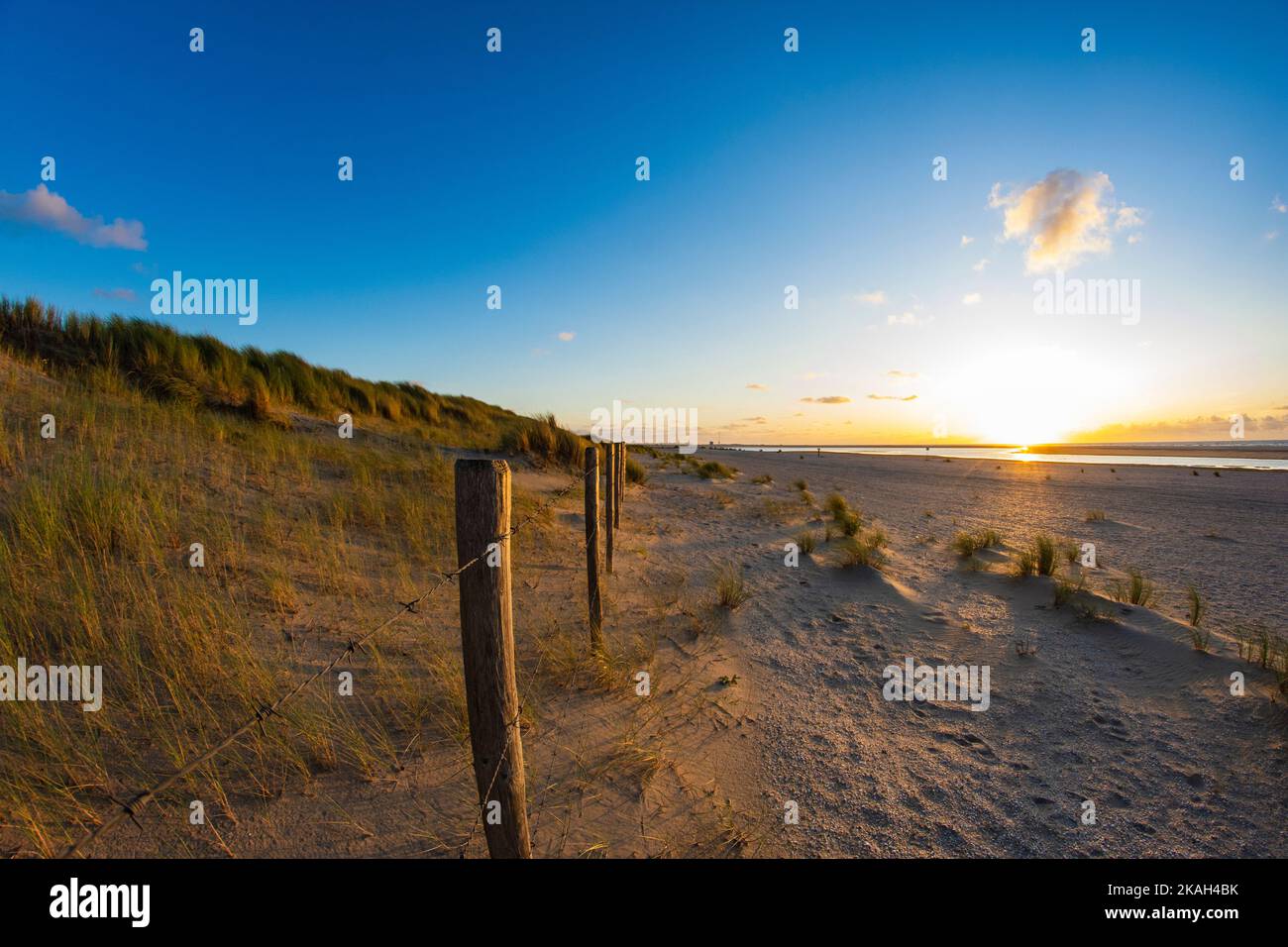Footpath and fence on the seashore during a calm sunset in summer. Stock Photo