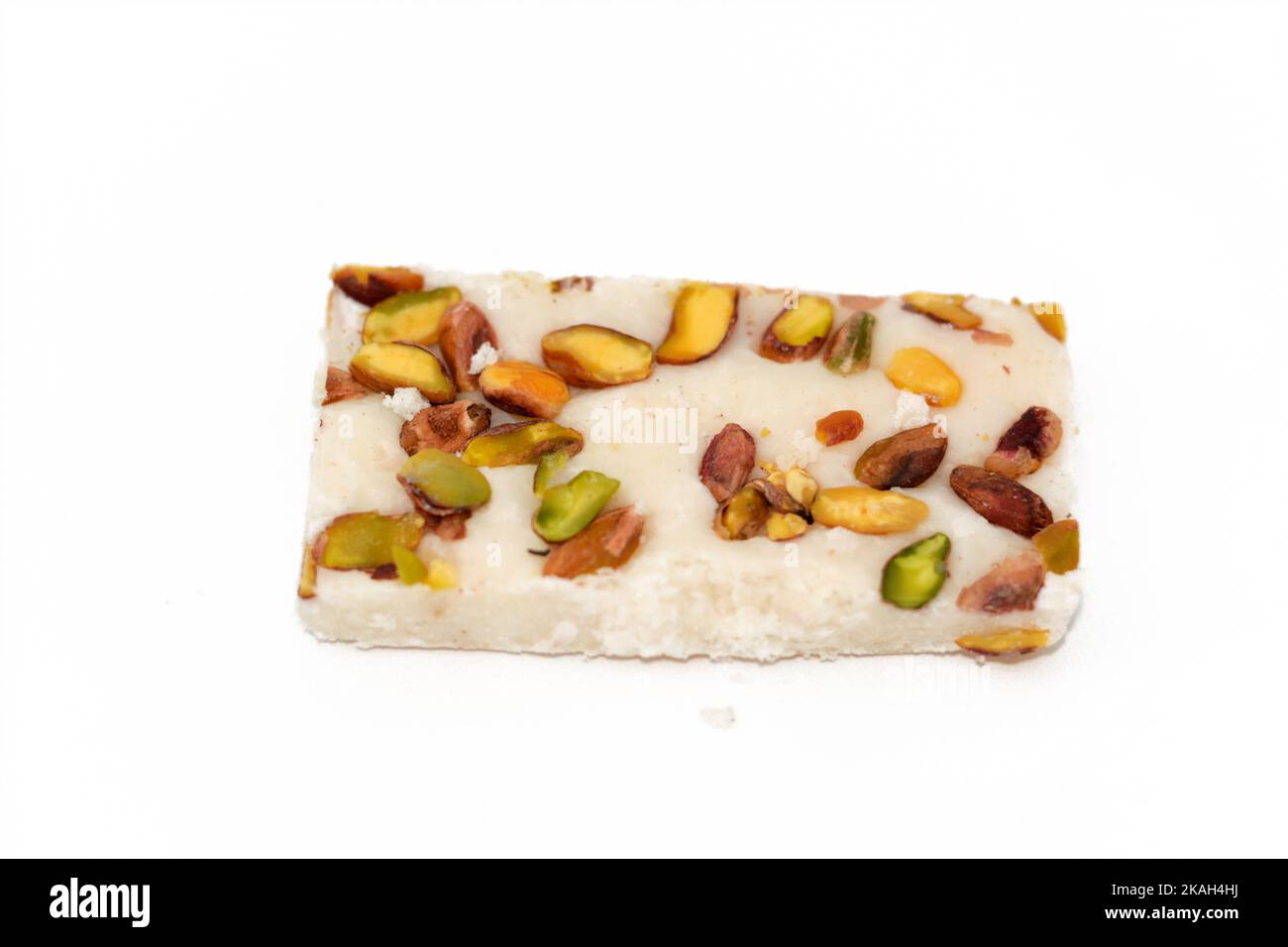 A piece of soft coconut Egyptian candy covered with pistachios, Egyptian cultural desserts of