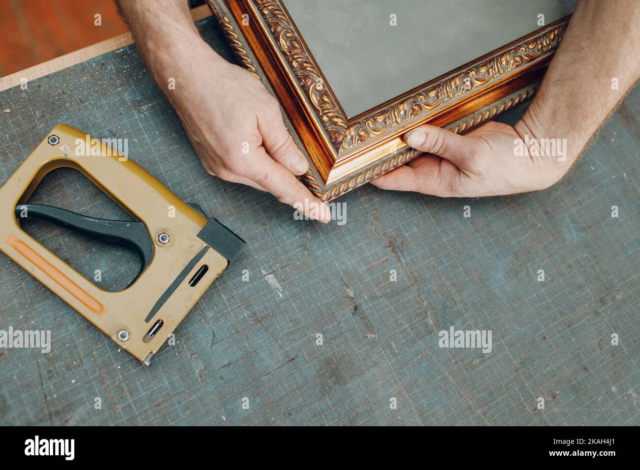 Framing Workshop. Making assembly stapler brackets baguette handmade picture frame at studio. Stock Photo