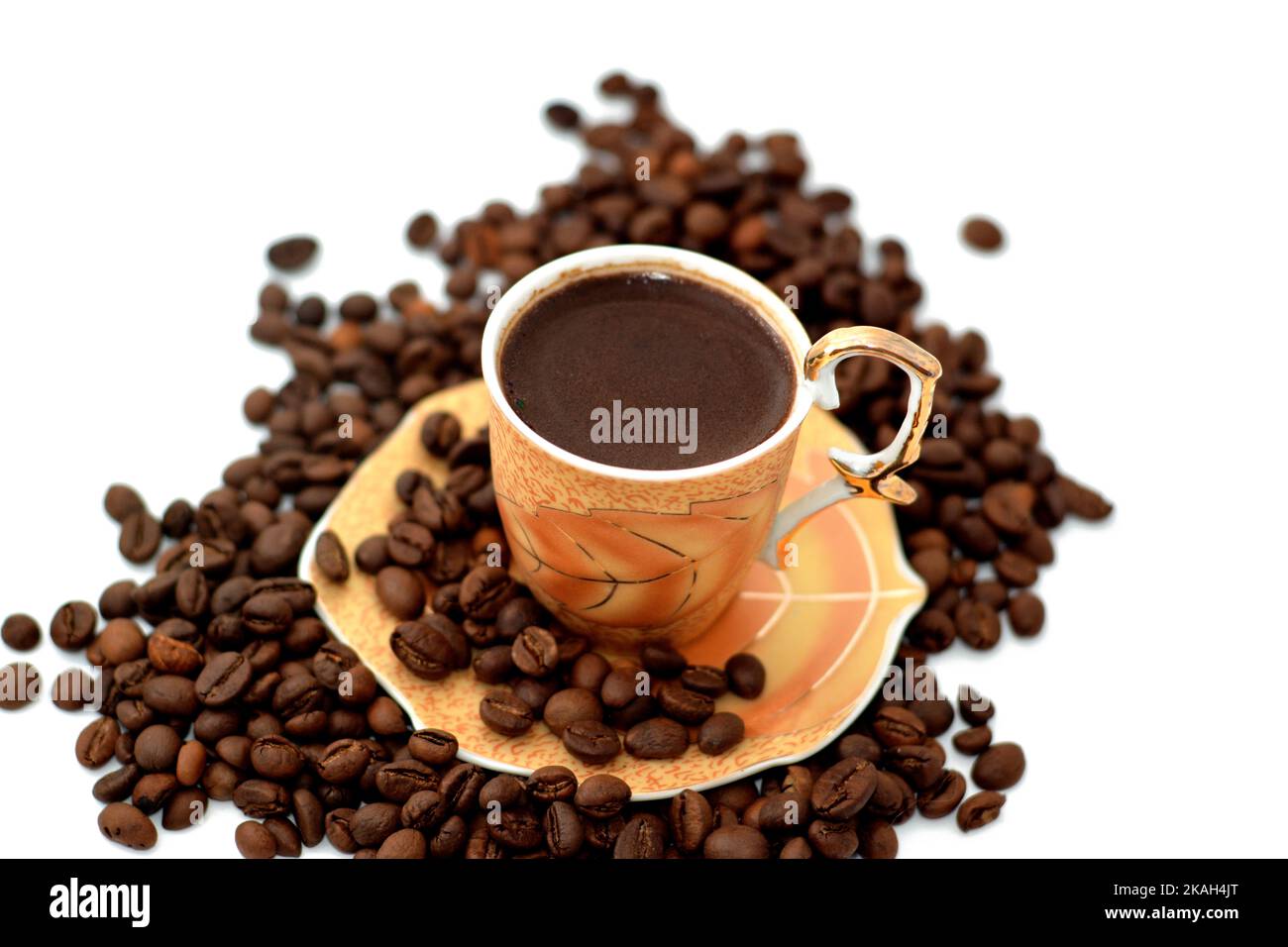 A cup of Turkish coffee with coffee beans, seeds of the Coffea plant and the source for coffee. It is the pip inside the red or purple fruit often ref Stock Photo
