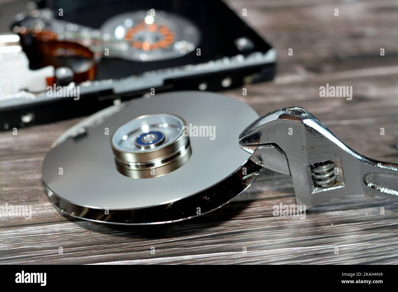 An adjustable spanner wrench and HDD platters together, hard disk drive disassembled damaged components, computer maintenance, recovery, data erase, d Stock Photo