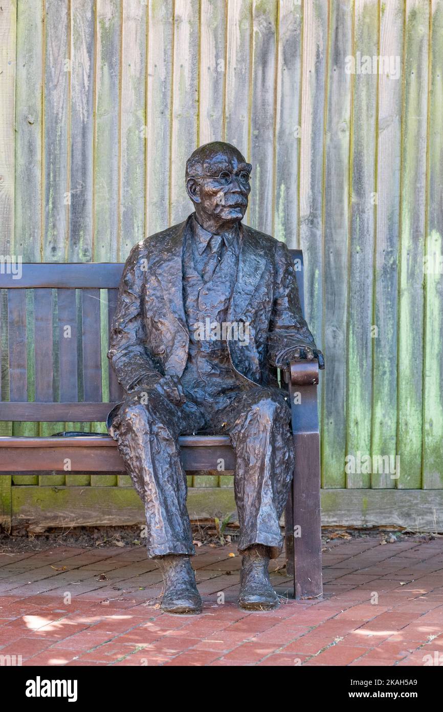 Life size statue of Rudyard Kipling by Victoria Atkinson sitting on a bench in Burwash, East Sussex, England, UK Stock Photo