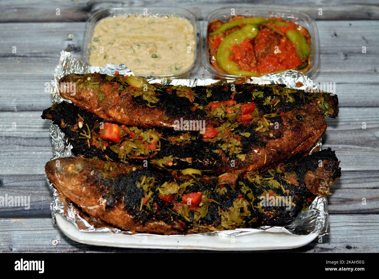 Charcoal grilled mullet fish with parsley and tomato, pickled eggplant