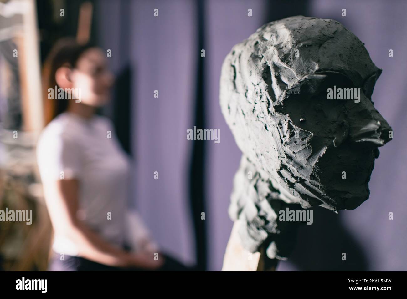 Man sculptor creates sculpt bust clay human woman sculpture. Statue