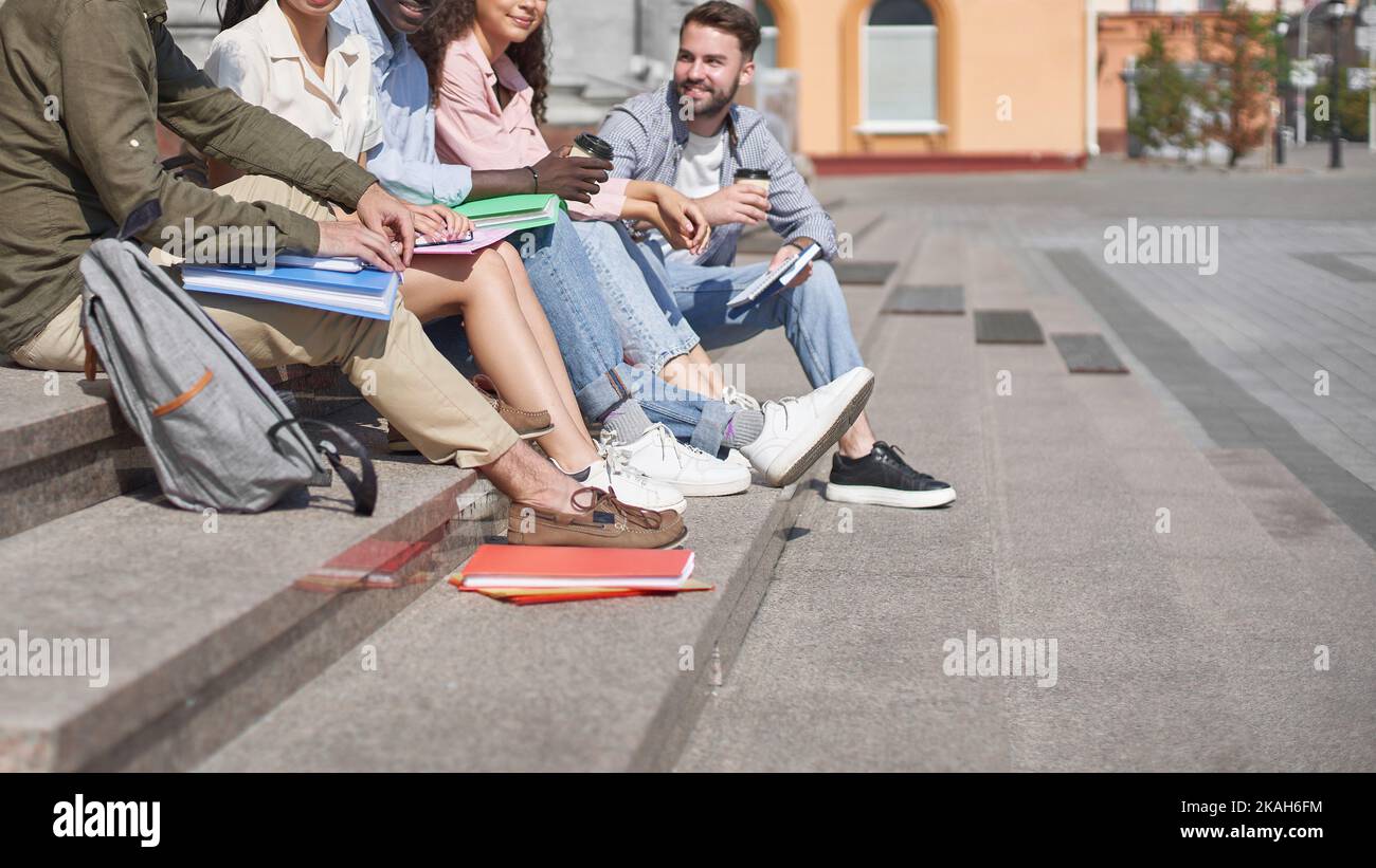 group of students communicates sitting on the steps Stock Photo