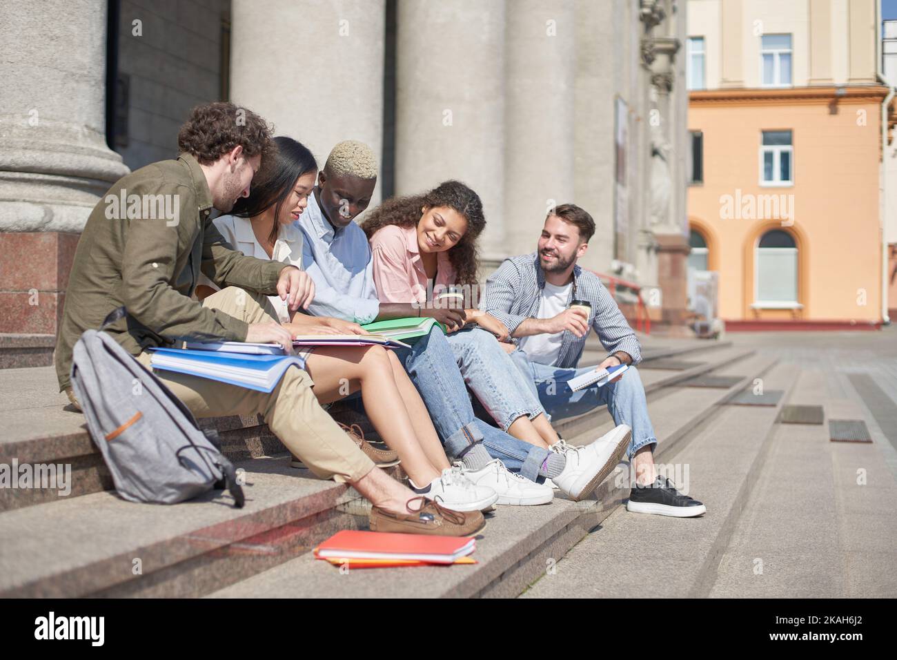 group of students communicates sitting on the steps Stock Photo