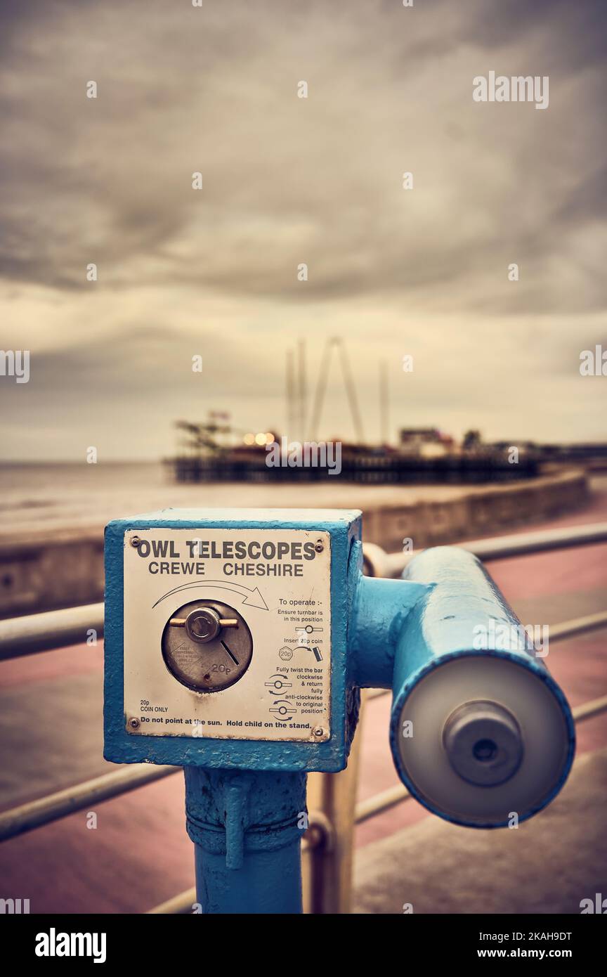 Telescope pointing at seaside pier on Blackpool seafront Stock Photo