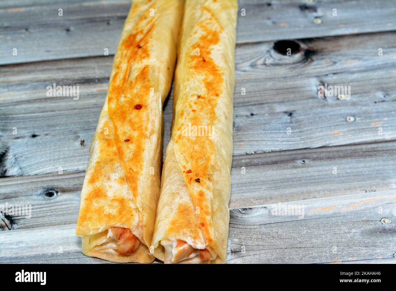 Syrian recipe cuisine background, chicken shawerma or shawarma tortilla wrap with onion, tomato, lettuce and garlic sauce in Syrian bread isolated on Stock Photo