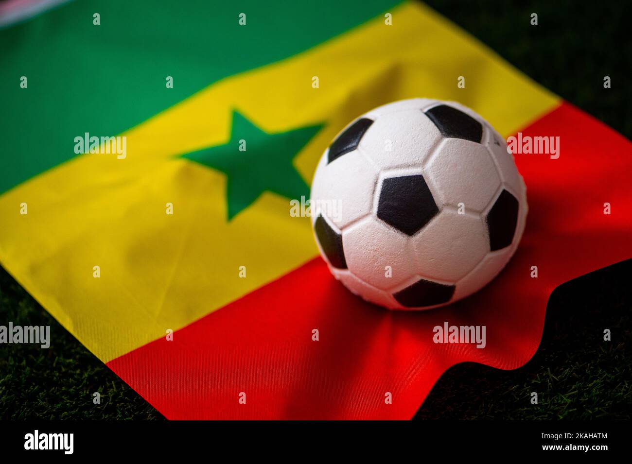Senegal national football team. National Flag on green grass and soccer ball. Football wallpaper for Championship and Tournament in 2022. World intern Stock Photo