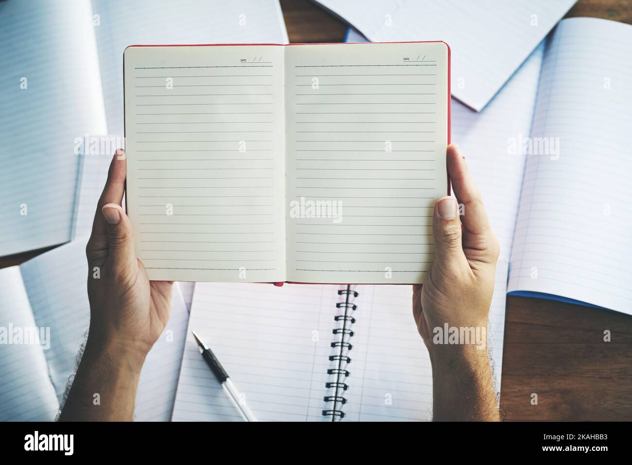 Time to start a new chapter. High angle shot of an unrecognisable person sitting with blank notebooks at a desk. Stock Photo
