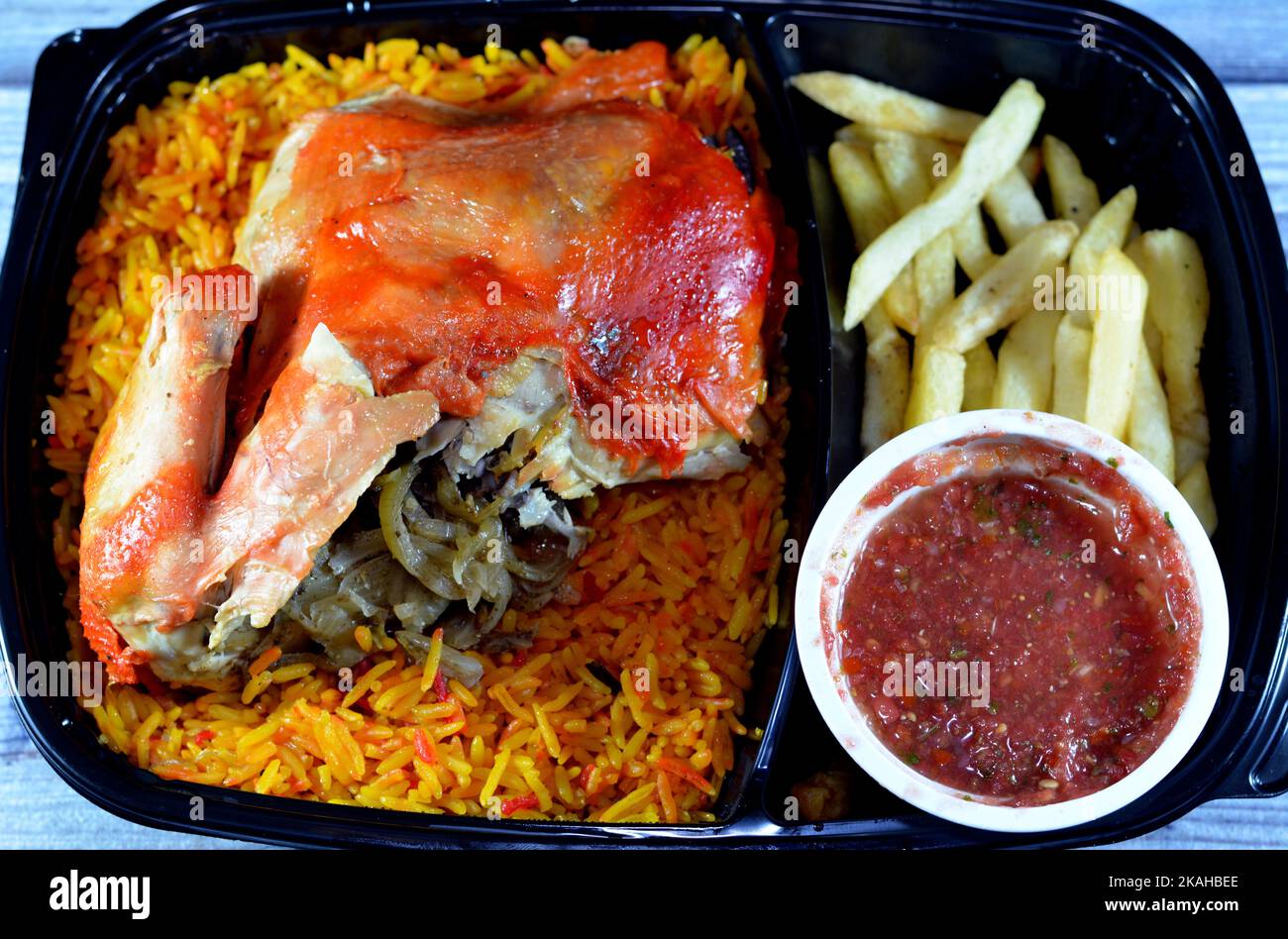 Chicken mandi with long basmati rice and french fries, served with tomato dakos sauce, selective focus of Yemen recipe of Mandi chicken with spices an Stock Photo