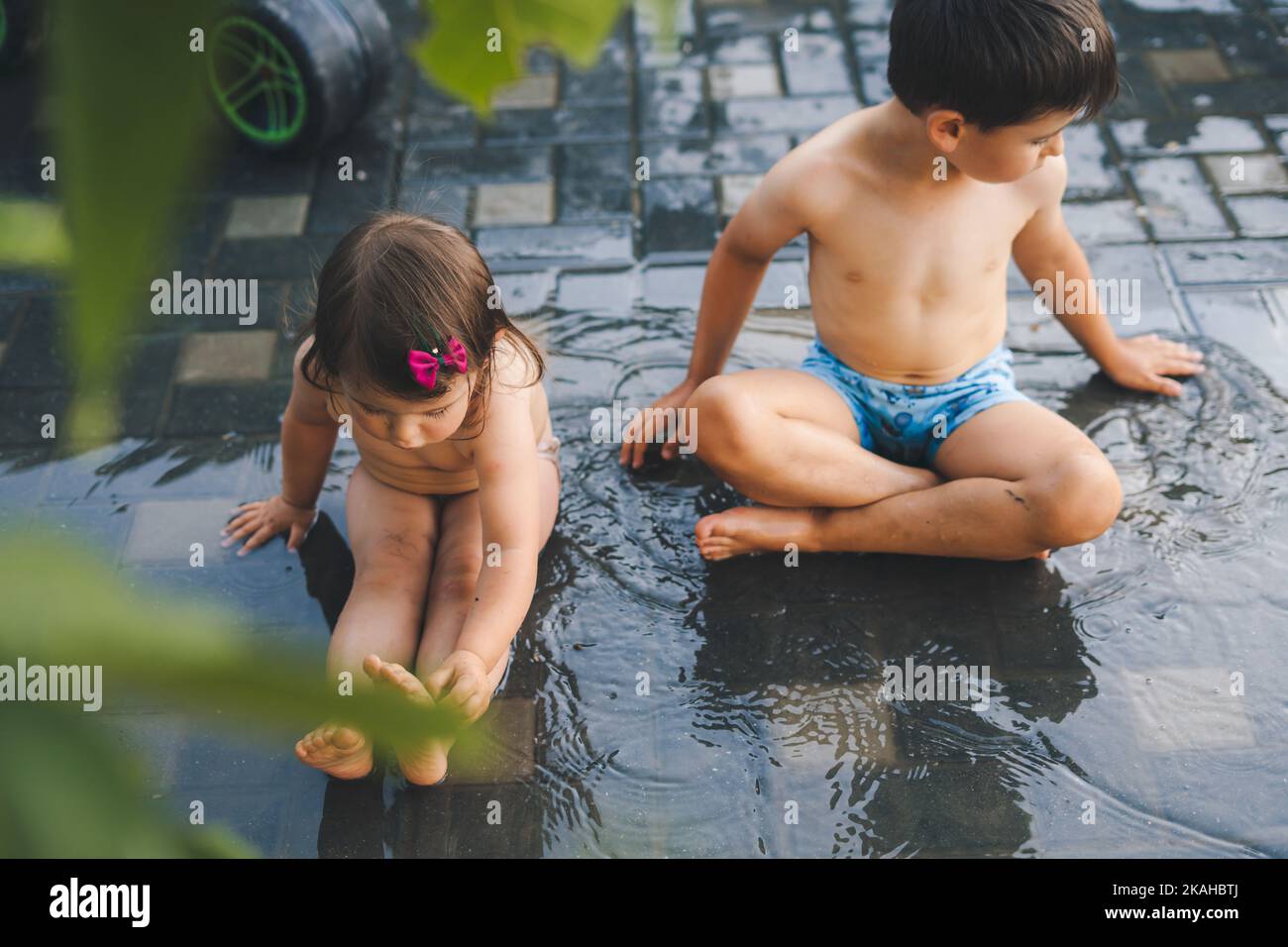 Kids playing in rain hi-res stock photography and images - Alamy