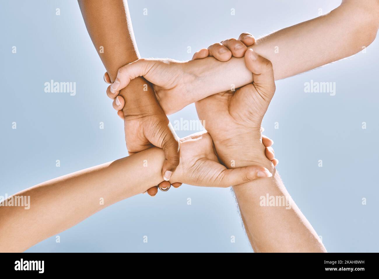 Wrist hands, teamwork and diversity, support or community, trust or cooperation on blue sky. Collaboration, business people holding arms or motivation Stock Photo
