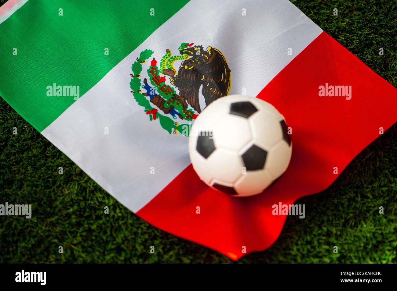 Mexico national football team. National Flag on green grass and soccer ball. Football wallpaper for Championship and Tournament in 2022. World interna Stock Photo