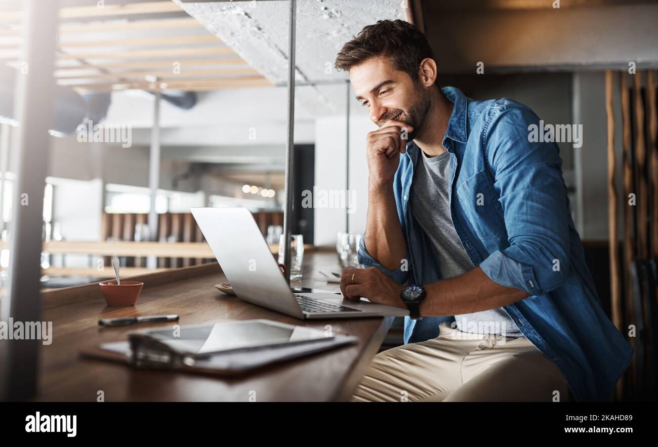 Get connected, get productive. a handsome young man using a laptop in a coffee shop. Stock Photo