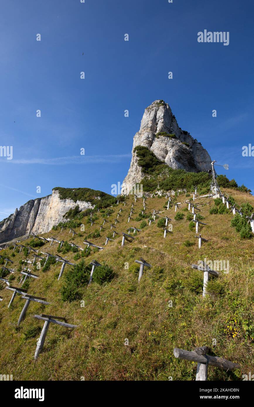View from below over a meadow with avalanche barriers to a steep rocky peak in the Alpstein in Switzerland. Stock Photo