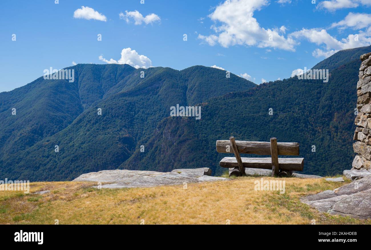 Cozy wooden bench at a picturesque vantage point high above the Valle Maggia in Switzerland. Stock Photo