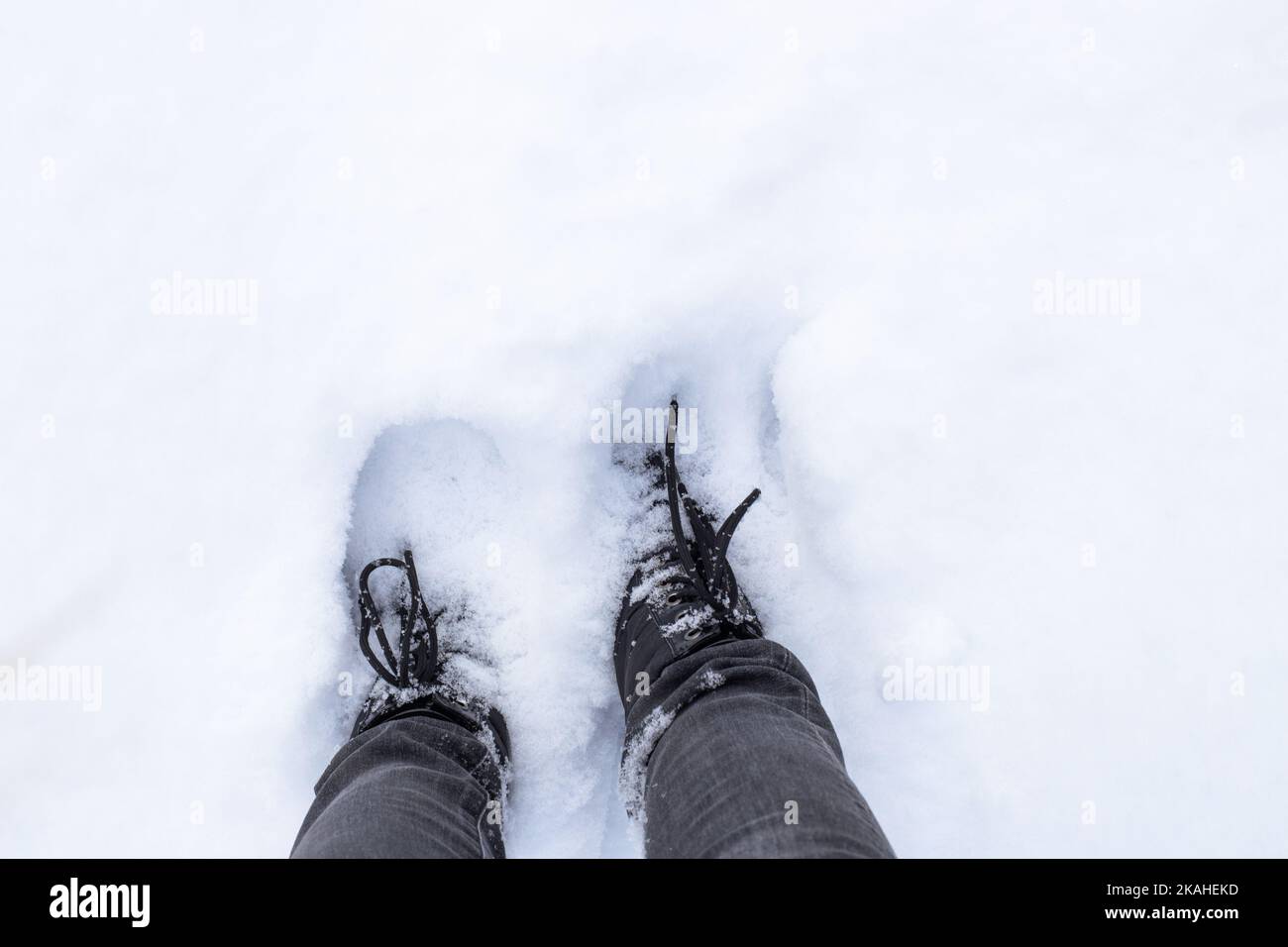 Walk along the snow path. Feet in boots are deep in the snow. Stock Photo