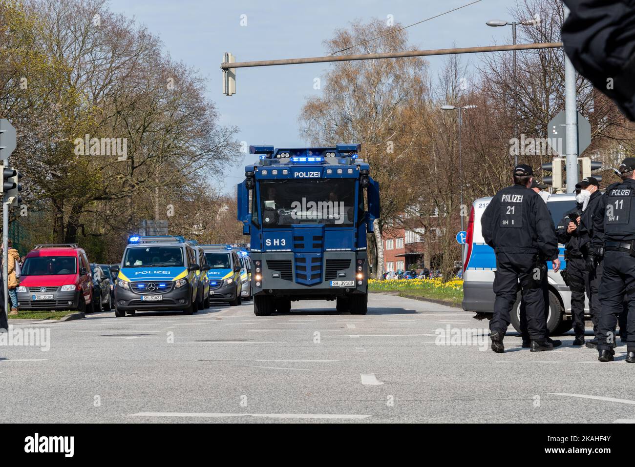 Polizeieinsatzfahrzeuge und ein Wasserwerfer im Einsatz bei einer Demonstration Stock Photo