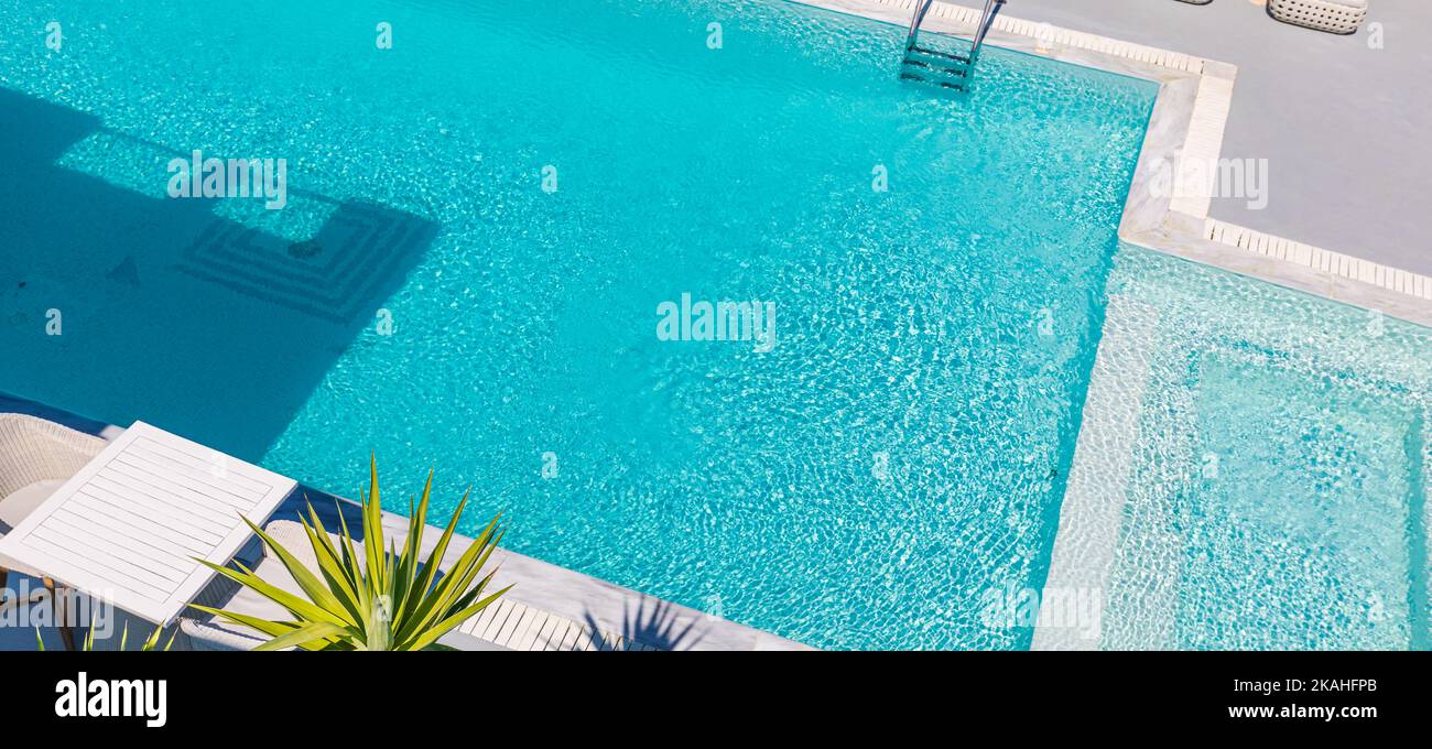 Aerial view of a blue pool full of clean water. Around to make marble tiles by the pool edge, palm leaves. Leisure lifestyle with idyllic private pool Stock Photo