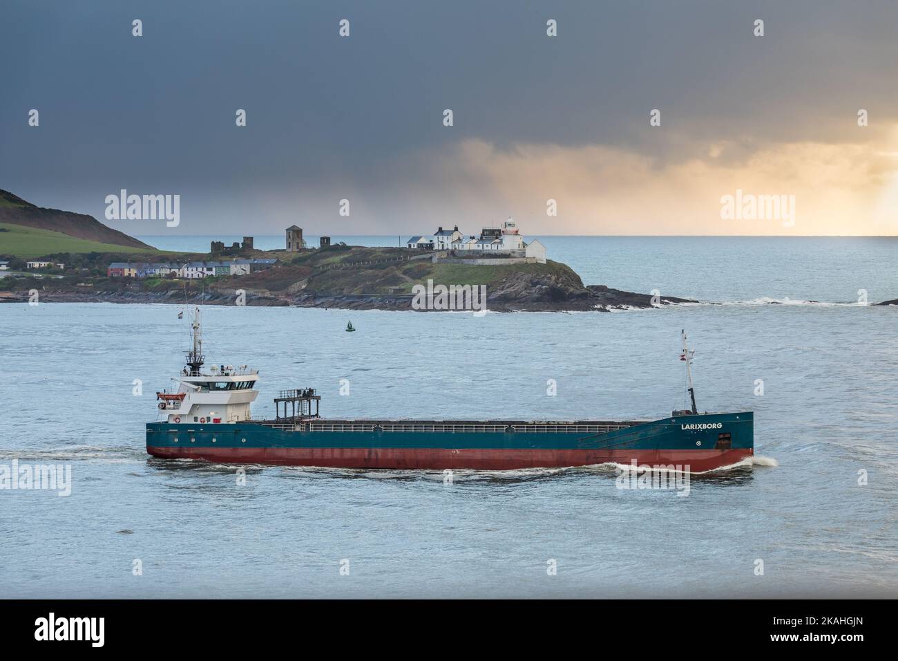 Roches Point, Cork, Ireland. 03rd November, 2022. General cargo ship Larixborg leaves the harbour at dawn bound for the UK, as rain clouds gather at Roches Point, Cork, Ireand. - Picture David Creedon Stock Photo