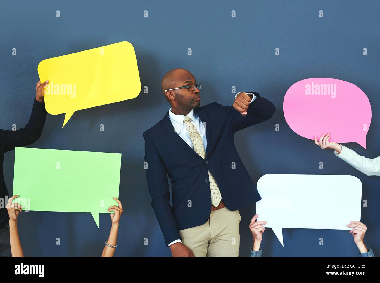 Dont waste your time listening to the naysayers. people holding up speech bubble around a young man. Stock Photo