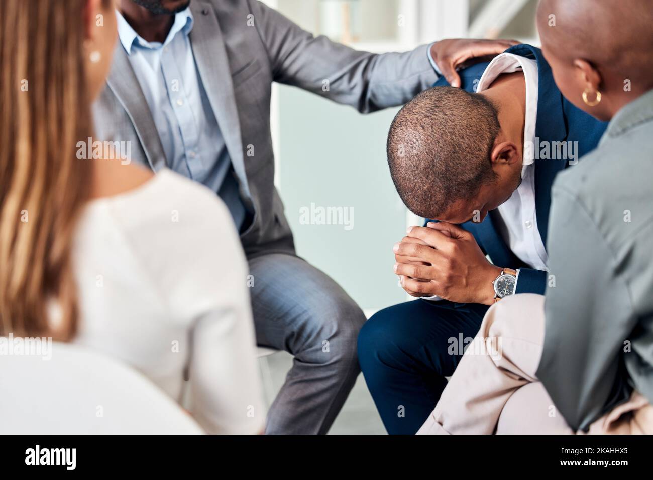 Group therapy, support and counseling with a business man and team in a meeting for emotions or healing. Mental health, psychology and rehabilitation Stock Photo