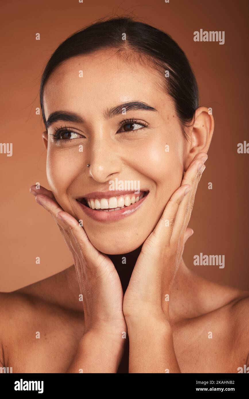 Skincare, makeup and woman thinking of cosmetics, dermatology and wellness from a spa against a brown studio background. Health, beauty and model with Stock Photo