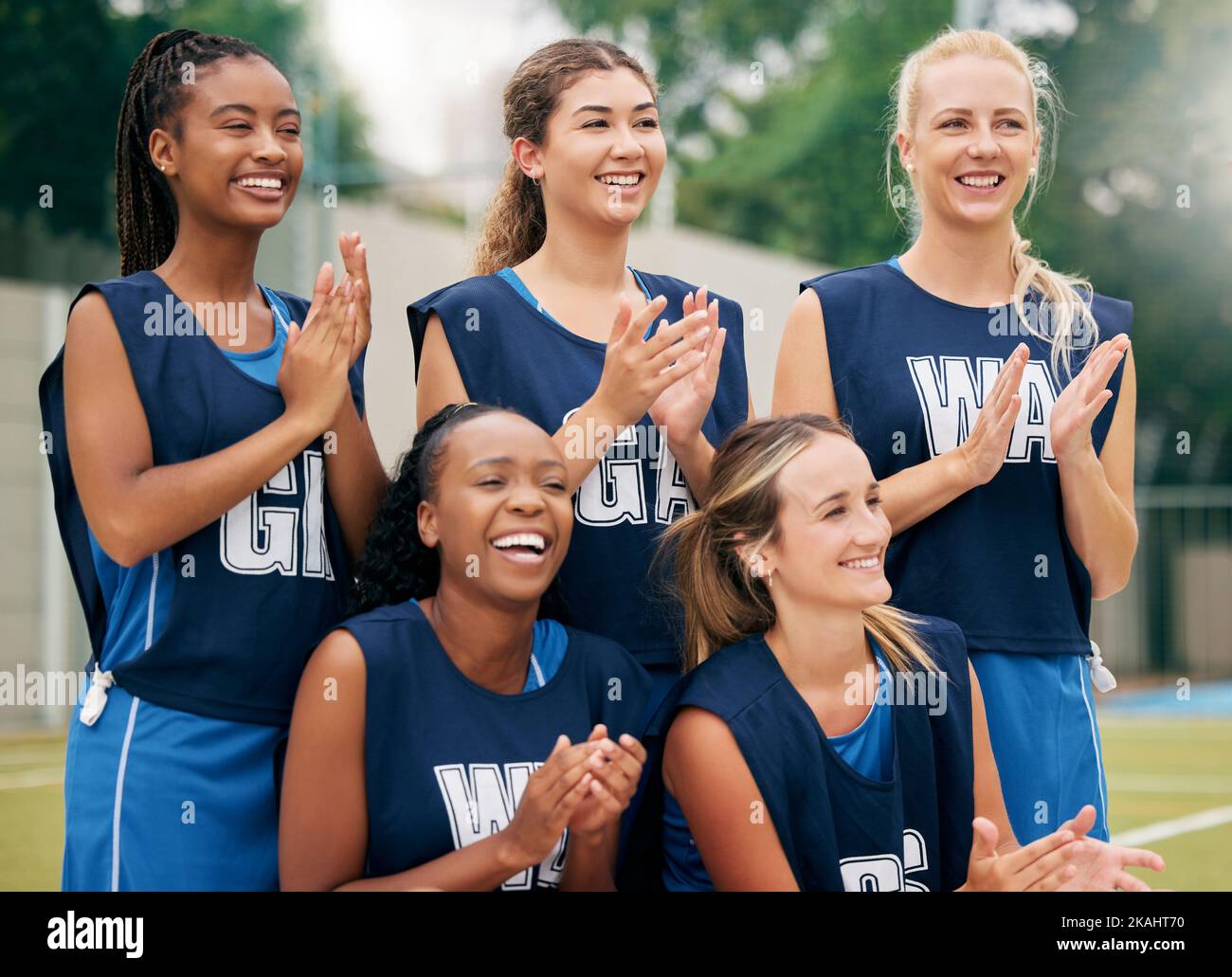 Netball, sports and women team applause, cheers and celebrate game, competition or training outdoor field support, motivation and teamwork. Happy Stock Photo