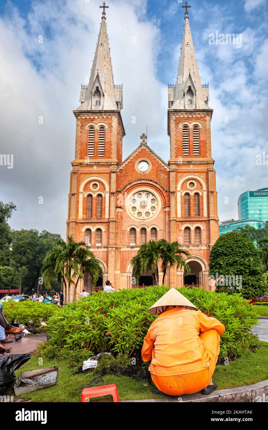 Vietnamese, municipal, worker, wearing, bamboo, hat, pruning, bushes, front, of, Notre, Dame, Catholic, Cathedral, Ho Chi Minh, City, Vietnam, work, u Stock Photo