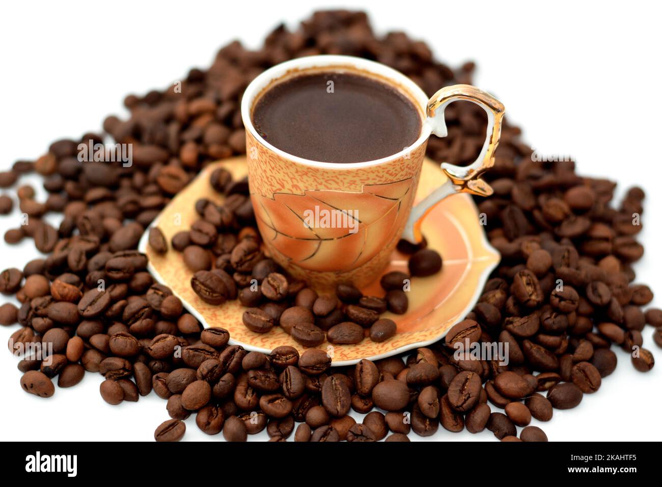 A cup of Turkish coffee with coffee beans, seeds of the Coffea plant and the source for coffee. It is the pip inside the red or purple fruit often ref Stock Photo