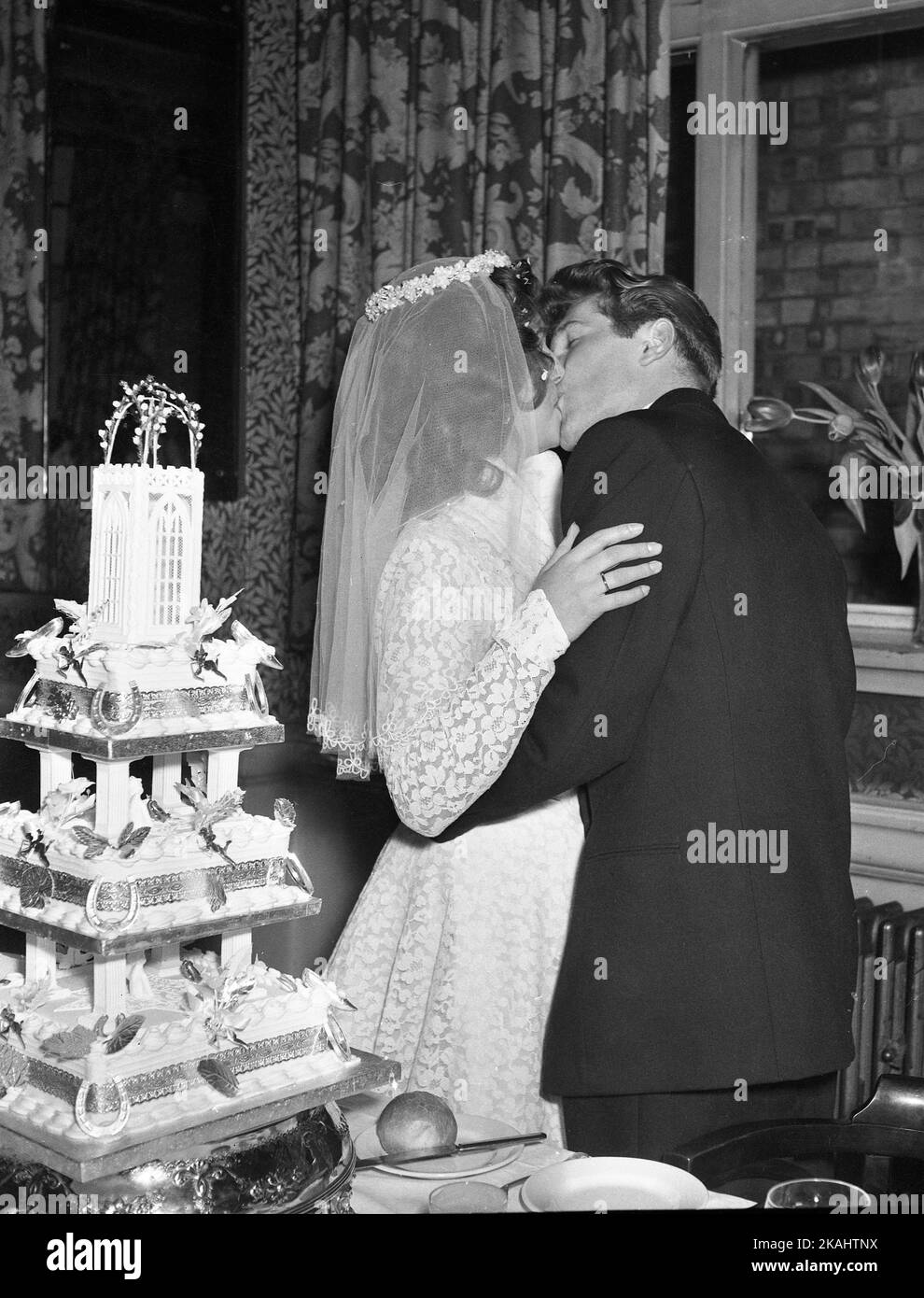 Wedding Day of Mr & Mrs Francis of 23 Myrtle Road, London E17 c1952 The newly-wed happy couple kiss by the wedding cake  Photo by Tony Henshaw Archive Stock Photo