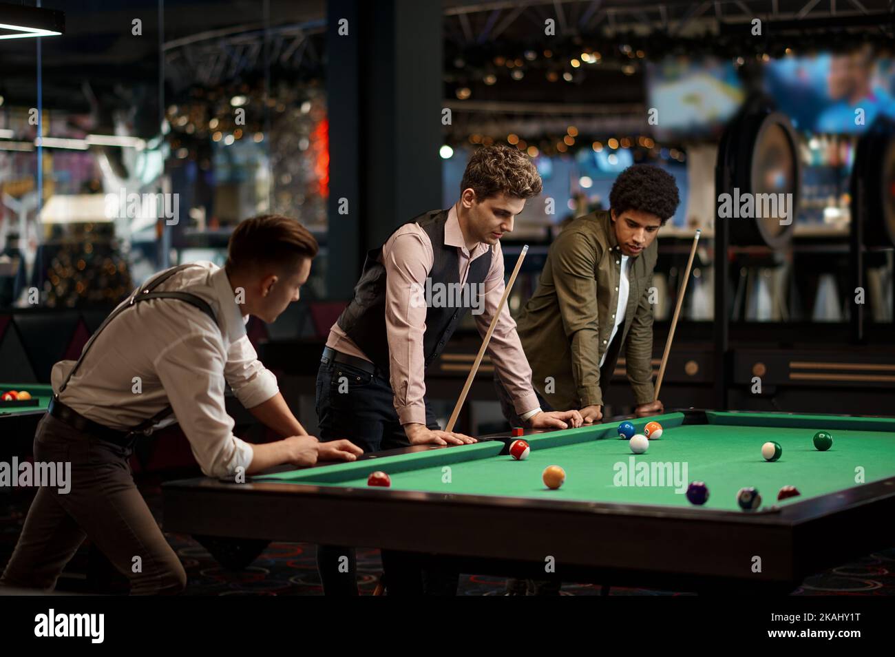 Company of handsome young guy playing in pool Stock Photo - Alamy