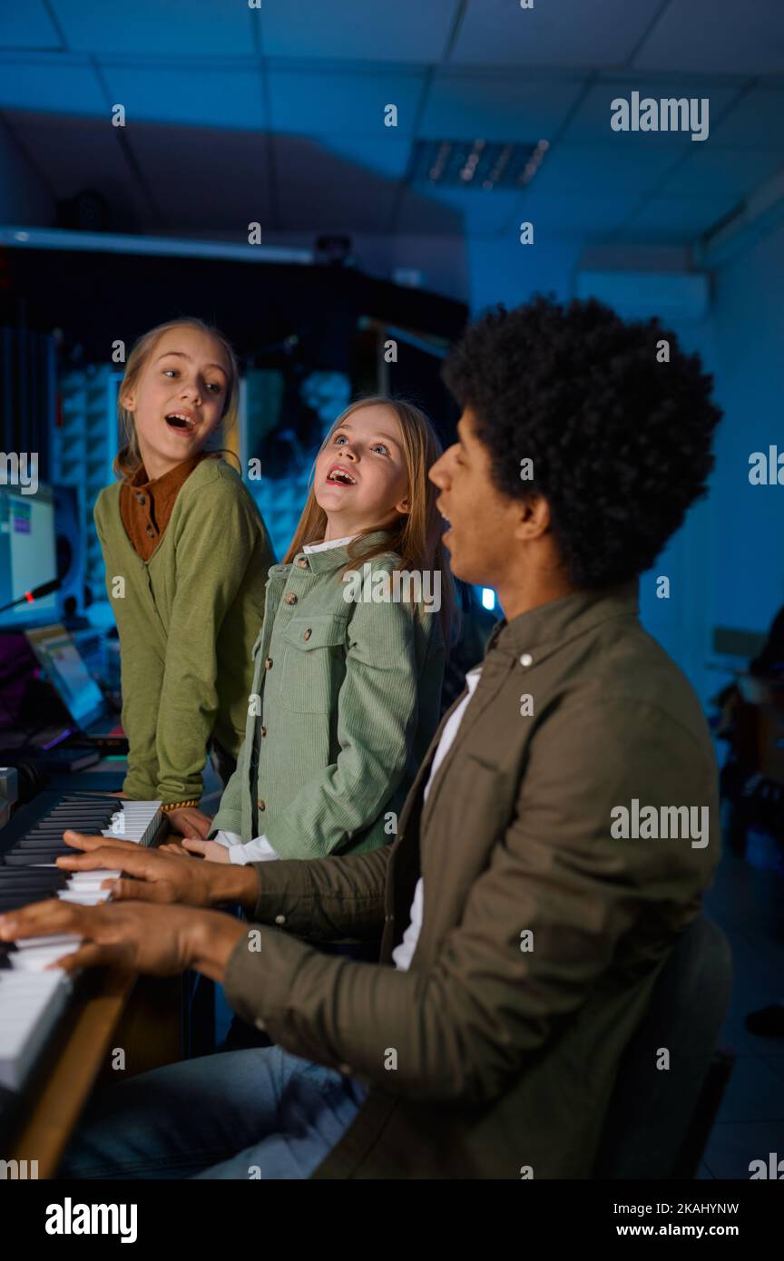 Children singing song to synthesizer accompaniment Stock Photo
