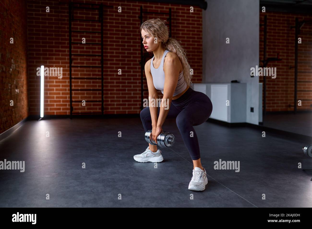 Woman training with dumbbells at gym club Stock Photo